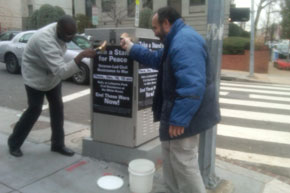 ANSWER volunteers put up posters for Dec. 16 2010 action